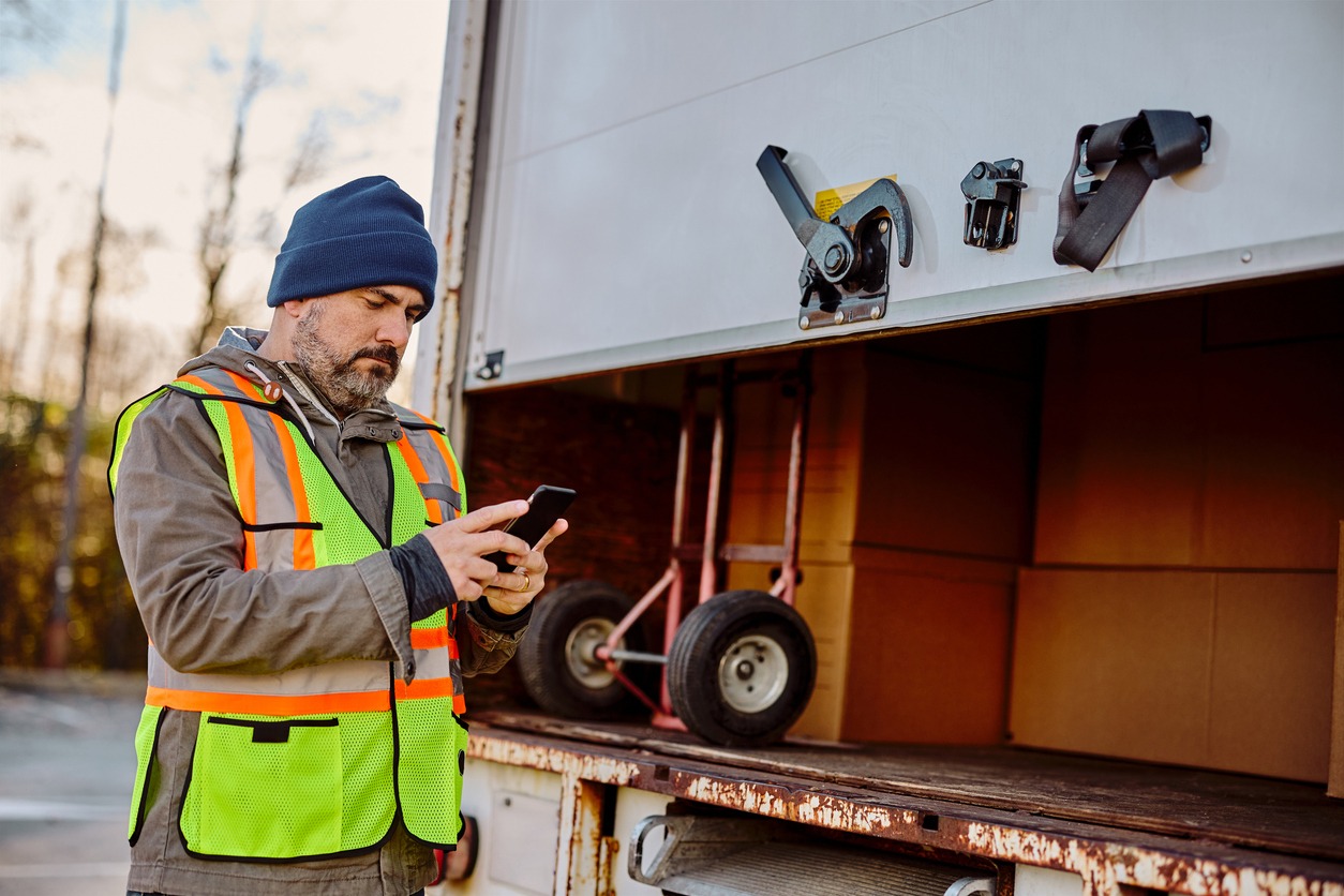 A truckdriver checks his cell phone.
